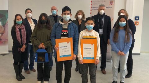 Eine Gruppe Schülerinnen und Schüle stehenr mit Staatssekretär Lösel