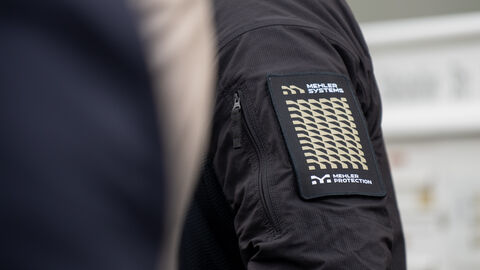 Nahaufnahme eines Jackenärmels mit dem Logo von Mehler Systems und der Aufschrift "Mehler Protection"