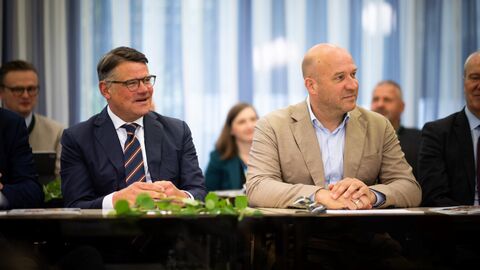 Ministerpräsident Rhein und Forstminister Jung sitzen nebeneinander an einem Tisch