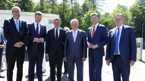 Ministerpräsident Boris Rhein posiert gemeinsam mit vier weiteren Personen im Freien.