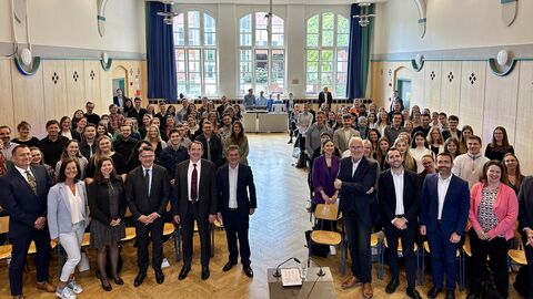 Ministerpräsident Rhein und Kultusminister Lorz mit allen vereidigten Referendaren in einem großen Saal.