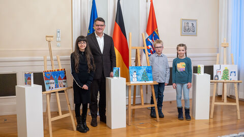Ministerpräsident Boris Rhein und die drei Kinder, die den Malwettbewerb gewonnen haben