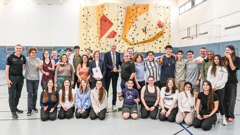 Kultusminister mit Schülerinnen und Schülern in Turnhalle